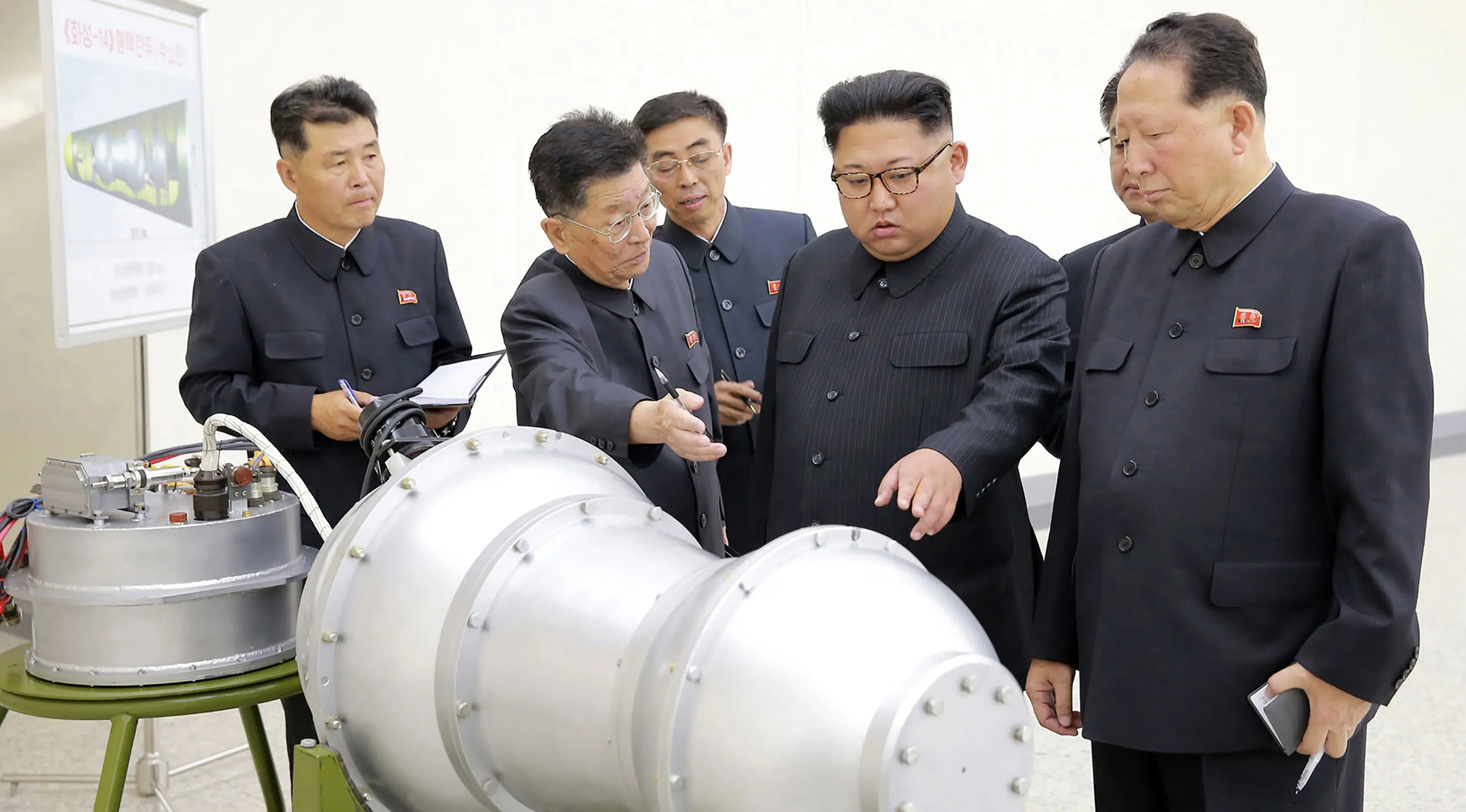 Kim Jong-un berbincang dengan para peneliti saat meninjau pembuatan bom hidrogen pada 3 September 2017. Bom ini diklaim berkekuatan hingga ratusan kiloton ini dibuat dengan berbagai komponen produksi dalam negeri. (AFP Photo/Kcna Via Kns/Str)
