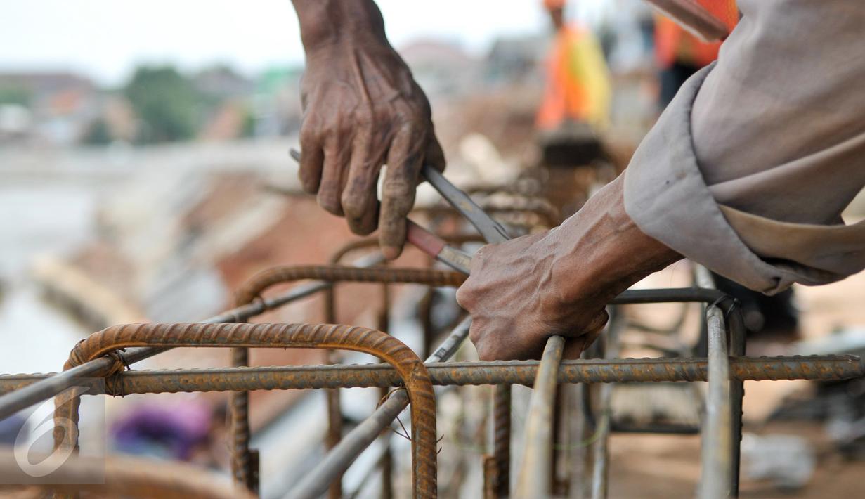 Pekerja memasang rangka untuk pengerjaan jalan di lokasi normalisasi sungai Ciliwung, Jakarta, Selasa (27/2). Proses normalisasi Sungai Ciliwung kembali dilanjutkan setelah terhenti karena meningginya air. (Liputan6.com/Yoppy Renato)