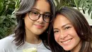 Ersa Mayori tampil bak kakak bagi anak perempuannya, Kika. Dalam foto ini, Kika yang mengenakan white t-shirt memberikan bunga tanda cinta untuk sang ibu yang terlihat mengenakan black top. Foto: Instagram.