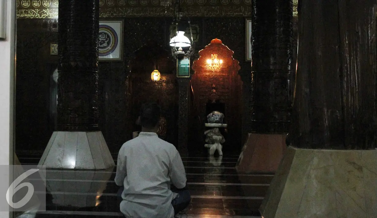 Pengunjung saat beribadah di Masjid Agung Al Munada Darussalam Baiturrahman, Jakarta, (24/6/ 2015). Terdapat tulisan kaligrafi petikan ayat kursi dari al-quran menghiasi dua tiang utama dari kayu jati. (Liputan6.com/Helmi Afandi)