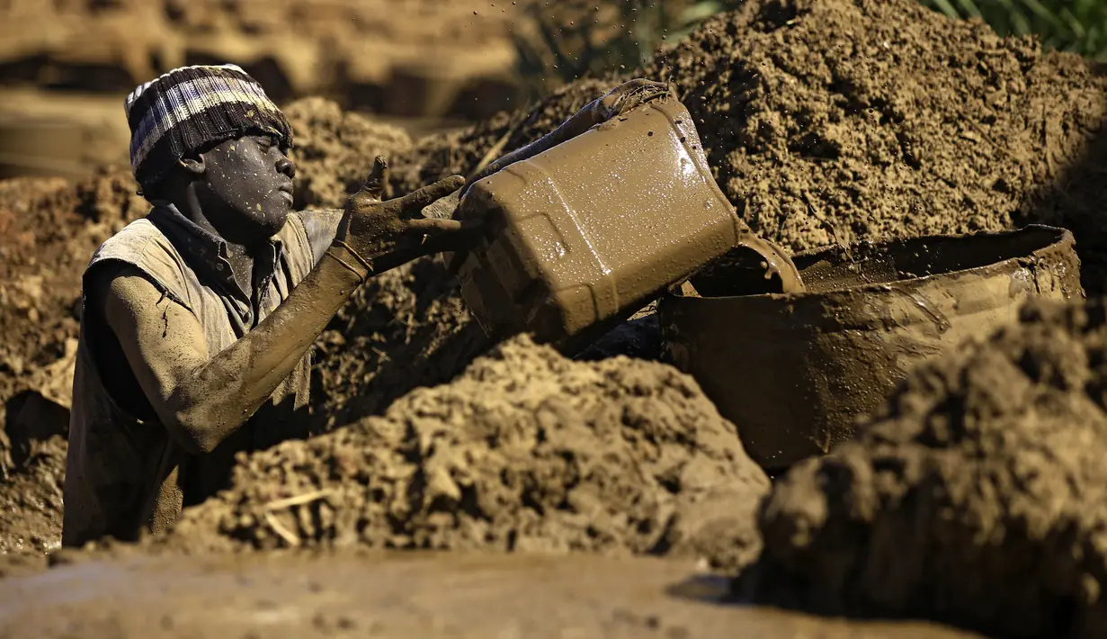 Seorang warga Sudan mengosongkan air dari lubang di bengkel tembikar di Omdourman, di pinggiran barat ibu kota Khartoum (19/1/2022). Pot tanah liat tersebut nantinya akan dipajang untuk dijual. (AFP/Ashraf Shazly)