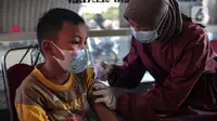 Petugas kesehatan menyuntikkan vaksin COVID-19 Sinovac kepada anak di Pospol Polsek Pamulang, Tangerang Selatan, Banten, Kamis (6/1/2022). Target vaksinasi bertujuan mendukung pembelajaran tatap muka (PTM) yang mulai dilaksanakan 100 persen pada pekan ini. (Liputan6.com/Faizal Fanani)