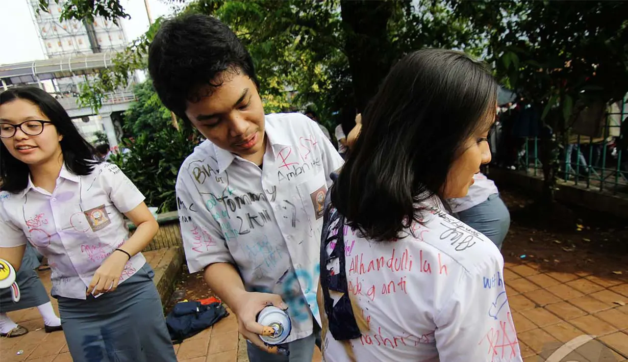Para siswa saling bergantian membubuhkan tanda tangan, ucapan kenangan atau hanya sekedar mencoretkan nama di seragam mereka, Jakarta, Selasa (20/5/2014) (Liputan6.com/Faizal Fanani)