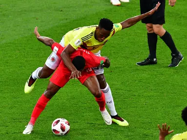 Bek timnas Kolombia, Yerry Mina berebut bola dengan pemain Inggris, Raheem Sterling pada babak 16 besar Piala Dunia 2018 di Stadion Spartak, Selasa (3/7). Selain adu penalti, sebuah kejadian menarik tertangkap kamera pada laga itu. (AFP/Mladen ANTONOV)
