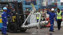 Petugas memindahkan salah satu bagian dari roda pesawat Lion Air PK-LQP JT 610 di Pelabuhan JICT 2, Jakarta, Senin (5/11). Bagian tersebut dipindah untuk dilakukan identifikasi dan pengecekan lebih lanjut oleh KNKT. (Liputan6.com/Helmi Fithriansyah)