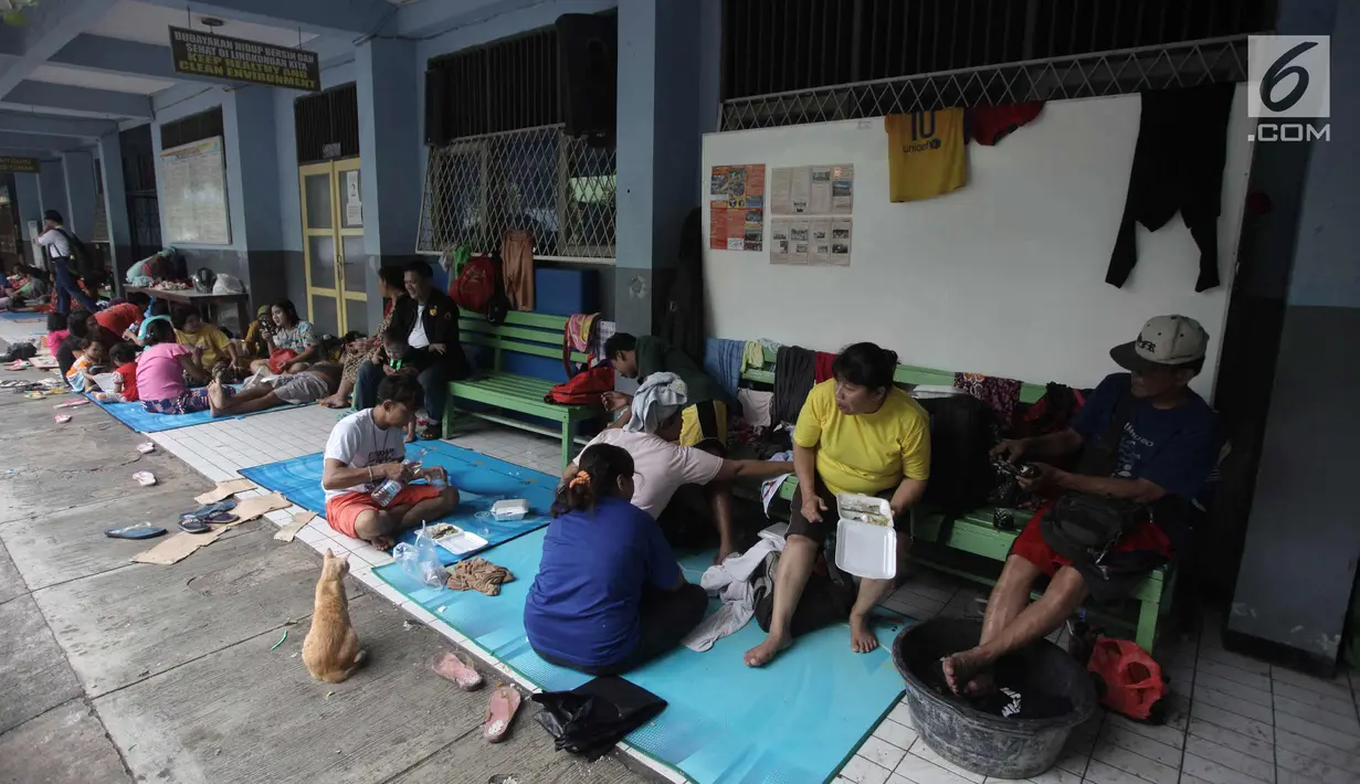 Aktivitas warga yang rumahnya terendam banjir mengungsi di Gedung SMP Negeri 26, Jalan Kebon Pala, Kampung Melayu, Jatinegara, Jakarta Timur, Selasa (6/2). Sebanyak 42 KK mengungsi di tempat tersebut. (Liputan6.com/Arya Manggala)