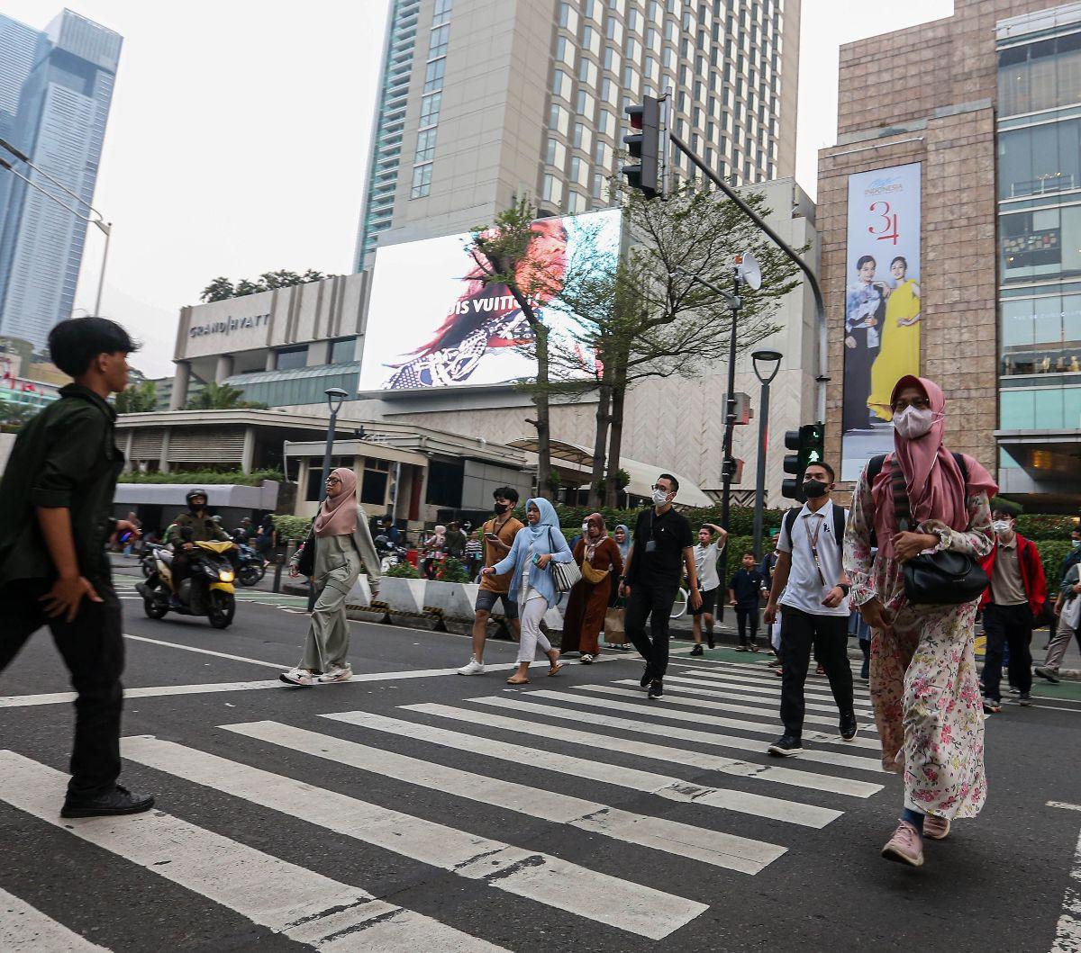 Para pekerja menyeberangi jalan saat jam pulang kantor di kawasan Jalan MH. Thamrin, Jakarta, Jumat (31/5/2024). Pemerintah menegaskan bahwa kebijakan pemotongan gaji para pekerja swasta maupun ASN/PNS untuk program Tabungan Perumahan Rakyat (Tapera) tak 