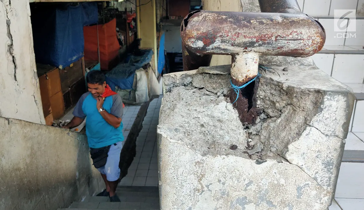 Seorang pria menaiki tangga di pasar tradisional Pasar Mingu di Jakarta, Rabu (17/7). Rencana revitalisasi 21 pasar tradisional di Ibu Kota terancam molor karena status lahan pasar masih dalam proses perubahan sertifikasi. (Liputan6.com/Immanuel Antonius)