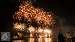 Warga menyaksikan atraksi kembang api perayaan tahun baru 2017 di Pantai Lagoon, Ancol, Jakarta (1/1). Antusiasme warga menyambut tahun 2017 diramaikan dengan pesta kembang api di sejumlah sudut Ibu Kota. (Liputan6.com/Gempur M. Surya)