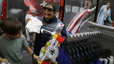 David Prego dan ayahnya memilih pernak-pernik timnas Jerman di toko Soccer Locker, Florida, Rabu (13/6). Suporter sudah meramaikan pusat perbelanjaan untuk mendukung timnas Jerman yang akan berlaga di Piala Dunia 2018 Rusia. (Joe Raedle/Getty Images/AFP)