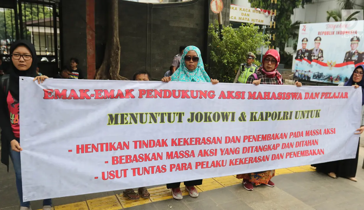 Kaum ibu yang tergabung dalam Emak-Emak Indonesia membentangkan spanduk saat aksi di Gedung Polda Metro Jaya, Jakarta, Minggu (29/9/2019). Mereka juga menuntut Presiden Jokowi memecat anggota polisi yang bertindak brutal, dan bebaskan aktivis yang masih ditahan. (Liputan6.com/Herman Zakharia)