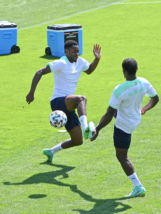 Pemain timnas Swiss, Edimilson Fernandes (kiri) dan Jordan Lotomba ambil bagian dalam sesi latihan di pusat olahraga Tre Fontane di Roma, Selasa (15/6/2021). Timnas Italia akan meladeni Swiss di Stadio Olimpico pada laga kedua Grup A Euro 2020, Kamis dini hari WIB. (ANDREAS SOLARO / AFP)