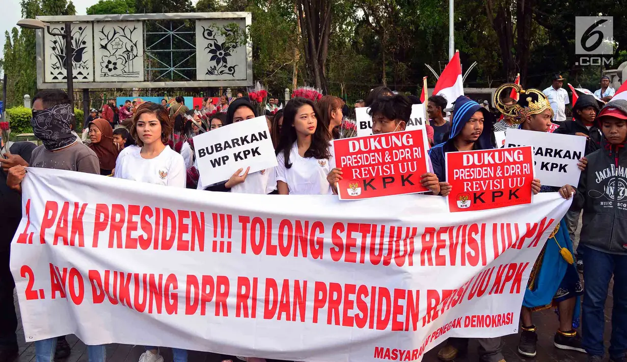 Massa membawa poster dalam aksi meminta revisi UU KPK di depan Istana, Jakarta, Jumat (13/9/2019). Dalam aksinya, mereka mendukung Presiden Jokowi dan DPR RI merevisi Undang-Undang KPK dalam rangka memperkuat langkah pemberantasan korupsi. (Liputan6.com/Johan Tallo)