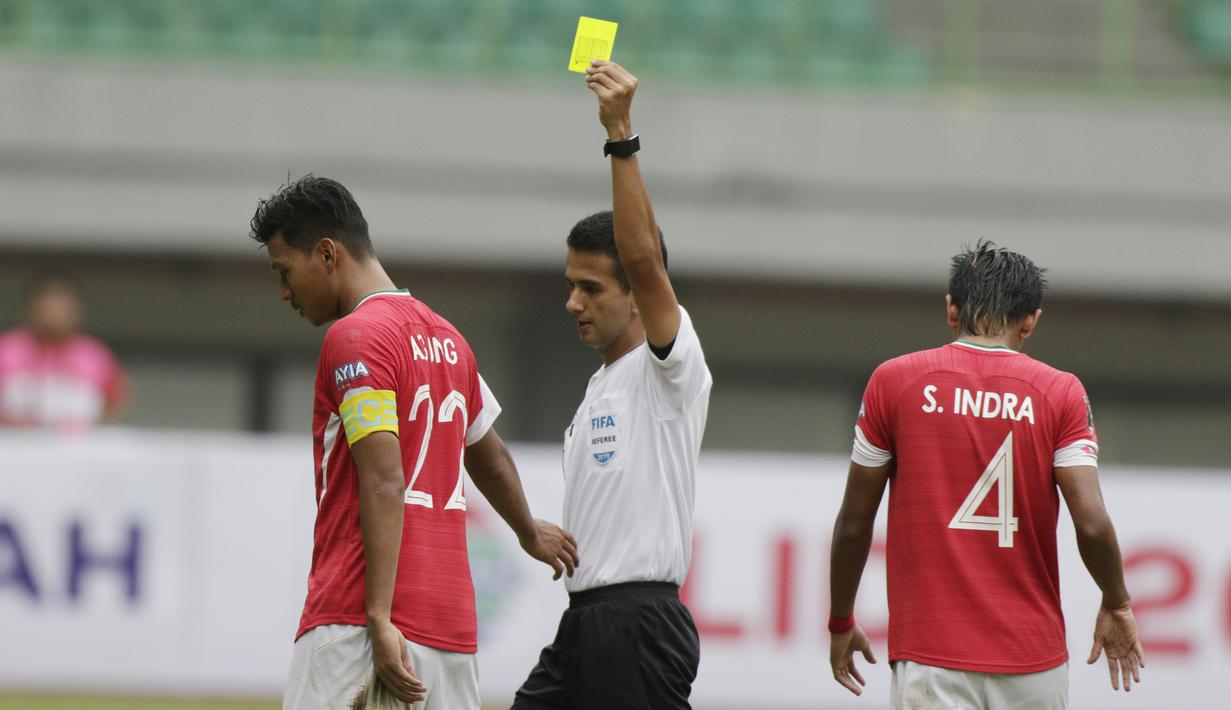 Wasit Thoriq Alkatiri memberikan kartu kuning kepada pemain Semen Padang pada laga Piala Presiden 2019 di Stadion Patriot, Jawa Barat, Minggu (3/3). Thoriq adalah salah satu wasit Indonesia yang berlisensi FIFA. (Bola.com/M Iqbal Ichsan)