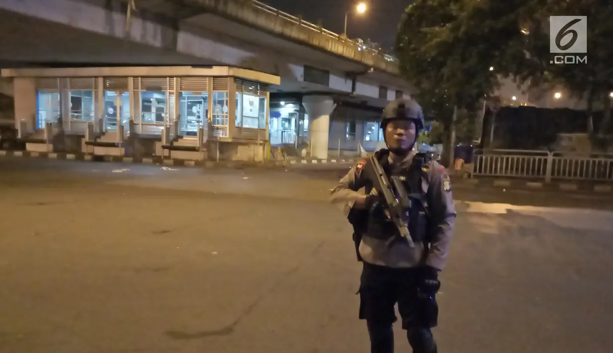 Polisi berjaga di sekitar halte Transjakarta usai terjadi ledakan di kawasan Kampung Melayu, Jakarta, Rabu (24/5). Sekitar lokasi langsung dijaga oleh petugas untuk melakukan penyisiran. (Liputan6.com/Herman Zakharia)