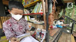 Anak-anak membaca buku di pustaka mini Bale Buku, Kramat Jati, Jakarta Timur, Kamis (20/01/2022). Bale buku yang diresmikan pada Sabtu (15/1) dibangun dari barang-barang bekas oleh komunitas Baca Bale Buku. (Liputan6.com/Herman Zakharia)