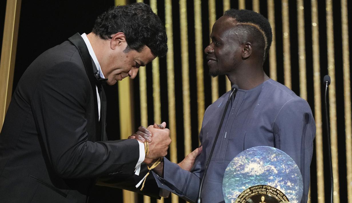 Penghargaan tersebut diserahkan langsung oleh Rai (kiri), mantan pemain timnas Brasil dan Paris Saint-Germain. Rai juga merupakan adik laki-laki Socrates, pesepakbola yang juga terlibat dalam aksi sosial di Brasil. (AP/Francois Mori)