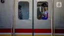 Penumpang bermain ponsel di dalam KRL di Stasiun Tanah Abang, Jakarta, Sabtu (19/9/2020). Kereta-kereta terakhir meninggalkan wilayah DKI Jakarta sekitar pukul 19:00 WIB. Kapasitas pengguna tetap dibatasi hingga 74 orang per kereta. (Liputan6.com/Faizal Fanani)