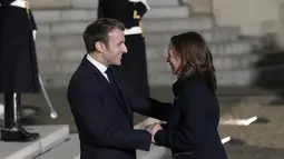 Presiden Prancis Emmanuel Macron menyambut kedatangan Wakil Presiden AS, Kamala Harris menjelang pertemuan di Istana Elysee, Rabu (10/11/2021). Kamala Harris bertemu dengan Macron dalam upaya untuk meredakan ketegangan terkait kesepakatan kapal selam yang dibatalkan. (AP Photo/Christophe Ena)