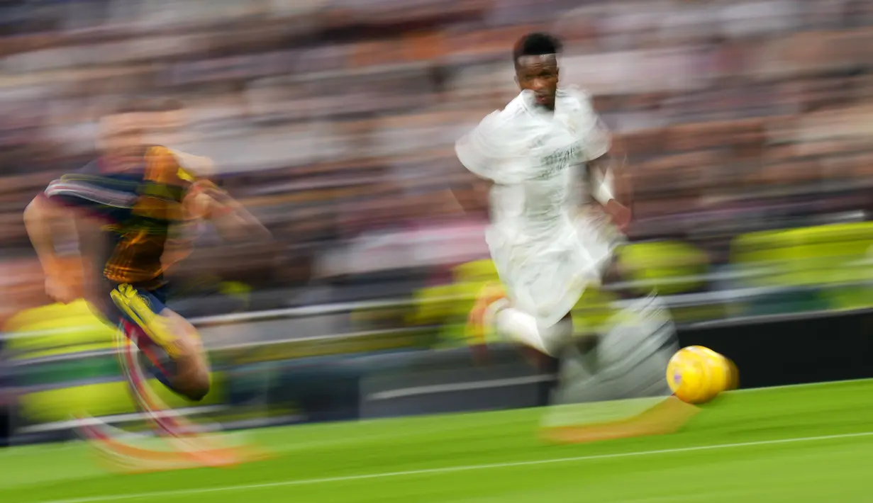 Pemain Real Madrid, Vinicius Junior menggiring bola melewati pemain Girona dalam laga lanjutan Liga Spanyol 2024/2025 di Santiago Bernabeu Stadium, Madrid, Minggu (23/02/2025) waktu setempat. (AP Photo/Manu Fernandez)