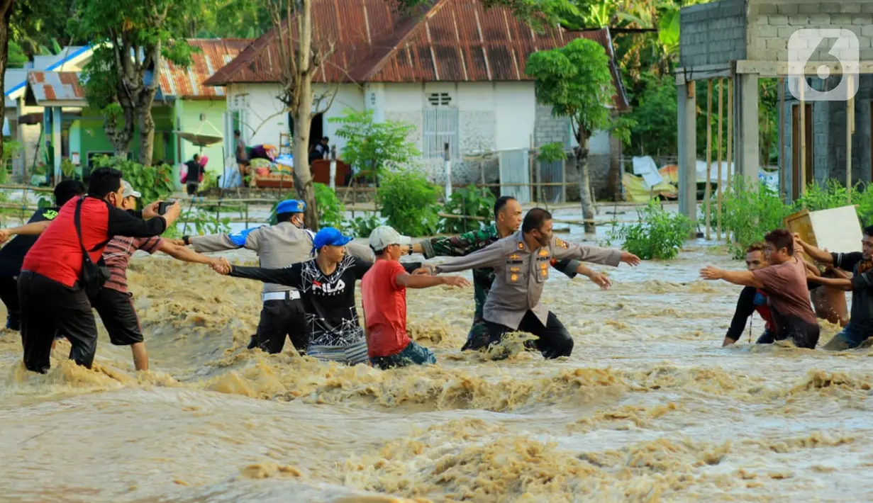 Petugas berusaha mengevakuasi warga saat banjir bandang  di Kabupaten Bone Bolango, Gorontalo (11/6/2020). Data sementara yang diterima dari BPBD Kabupaten Bone Bolango sekitar 1.078 kepala keluarga serta 5.407 jiwa terdampak banjir bandang. (Liputan.com/Arfandi Ibrahim)