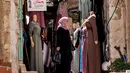 Seorang wanita berbelanja pakaian di pasar di kota tua Betlehem di Tepi Barat yang diduduki (14/9/2021). Penurunan bantuan asing, dengan ekonomi di Tepi Barat dan Gaza berkontraksi sebesar 11,5 persen pada tahun 2020, Otoritas Moneter Palestina melaporkan pertengahan Agustus. (AFP/Emmanuel Dunand)