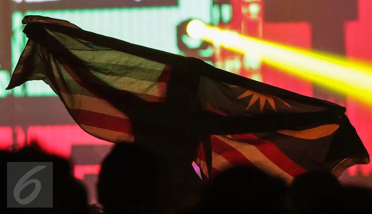 Seorang pengunjung membawa bendera Malaysia pada acara DWP 2016, di Kemayoran, Jakarta, Jumat. (09/12). DJ Marlo dan Breenan Heart menjadi penutup di hari pertama di panggung Cosmic Station. (Liputan6.com/Fery Pradolo)