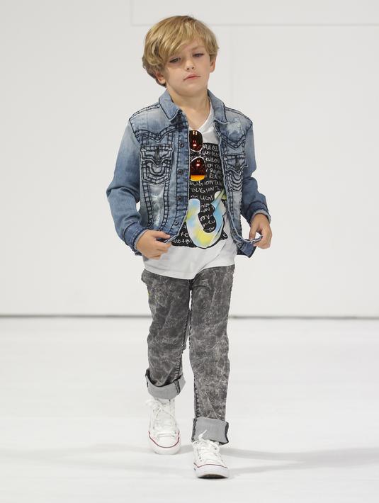Model cilik berjalan di atas catwalk membawakan koleksi True Religion pada saat petitePARADE di Children's Club di Jacob Javitz Center di New York City (6/8). (JP Yim / Getty Images untuk petitePARADE / AFP)