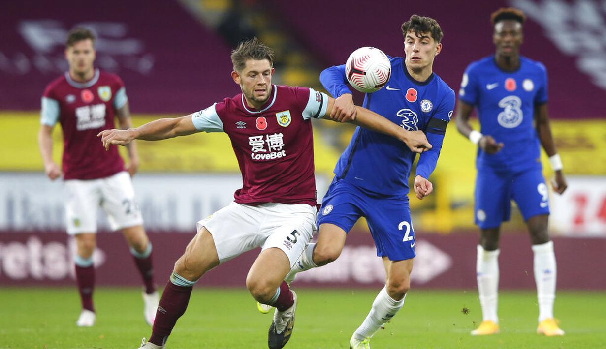 Pemain Chelsea, Kai Havertz, berebut bola dengan pemain Burnley, James Tarkowski, pada laga Liga Inggris di Stadion Turf Moor, Sabtu (31/10/2020). Chelsea menang dengan skor 3-0. (Molly Darlington/Pool via AP)