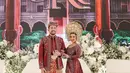 Saat resepsi, Kiky Saputri tampil mengenakan kebaya Minang dengan kerah sabrina. Kebaya rancangan Myrna Myura hadir dengan detail payetan mewah dan ekor panjang. [@myrnamyura].