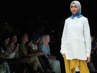 Model berpose membawakan busana rancangan kolaborasi antara desainer L.tru dan Mice Cartoon di Jakarta Fashion Week 2018 di Senayan City, Jakarta, Selasa (24/10). L.tru dan Mice Cartoon mengangkat tema "Dear Women. (Liputan6.com/Faizal Fanani)