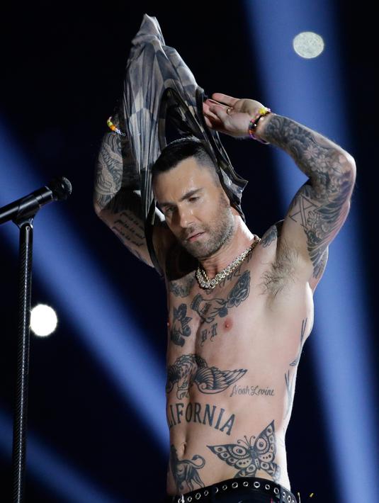 Vokalis Maroon 5 Adam Levine membuka bajunya saat tampil memeriahkan pertandingan antara Los Angeles Rams dan New England Patriots dalam Super Bowl LIII di Atlanta, Georgia, AS, Minggu (3/2). (AP Photo/Mark Humphrey)