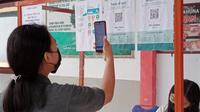 Para siswa menggunakan aplikasi PeduliLindungi sebelum masuk ke lingkungan sekolah di wilayah perbatasan RI-Filipina.