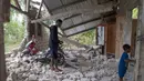Warga memeriksa rumahnya yang rusak akibat gempa di Lelak, provinsi Nusa Tenggara Timur, Indonesia, Minggu, 16 Agustus 2026. (AP Photo/Firdia Lisnawati)