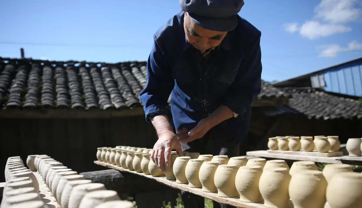 Seorang perajin bekerja di bengkel pembuatan tembikar di Desa Wanyao, Mazhan, Tengchong, Provinsi Yunnan, China, 18 November 2020. Kegiatan ini sebagai cara untuk melestarikan warisan budaya tembikar setempat. (Xinhua/Liang Zhiqiang)