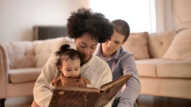 Orang tua membaca buku dengan anak