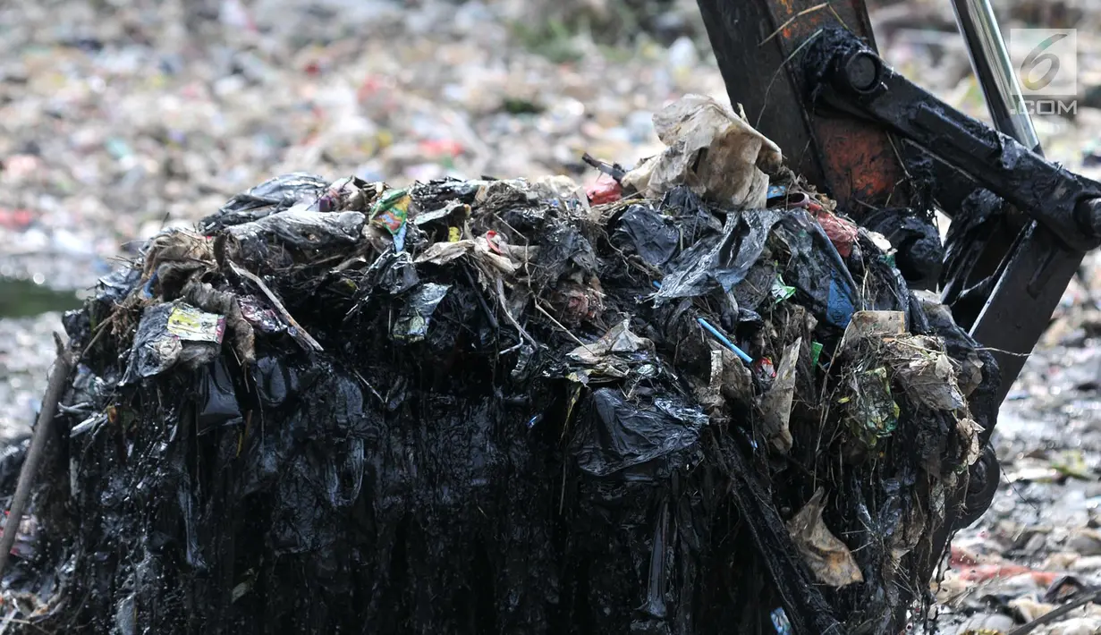 Alat berat saat mengeruk sampah yang memenuhi Kali Pisang Batu, Tarumajaya, Bekasi, Jawa Barat, Rabu (9/1). Lautan sampah yang memenuhi Kali Pisang Batu ini diduga berasal dari aliran kali di wilayah kota Bekasi. (Merdeka.com/Iqbal S. Nugroho)