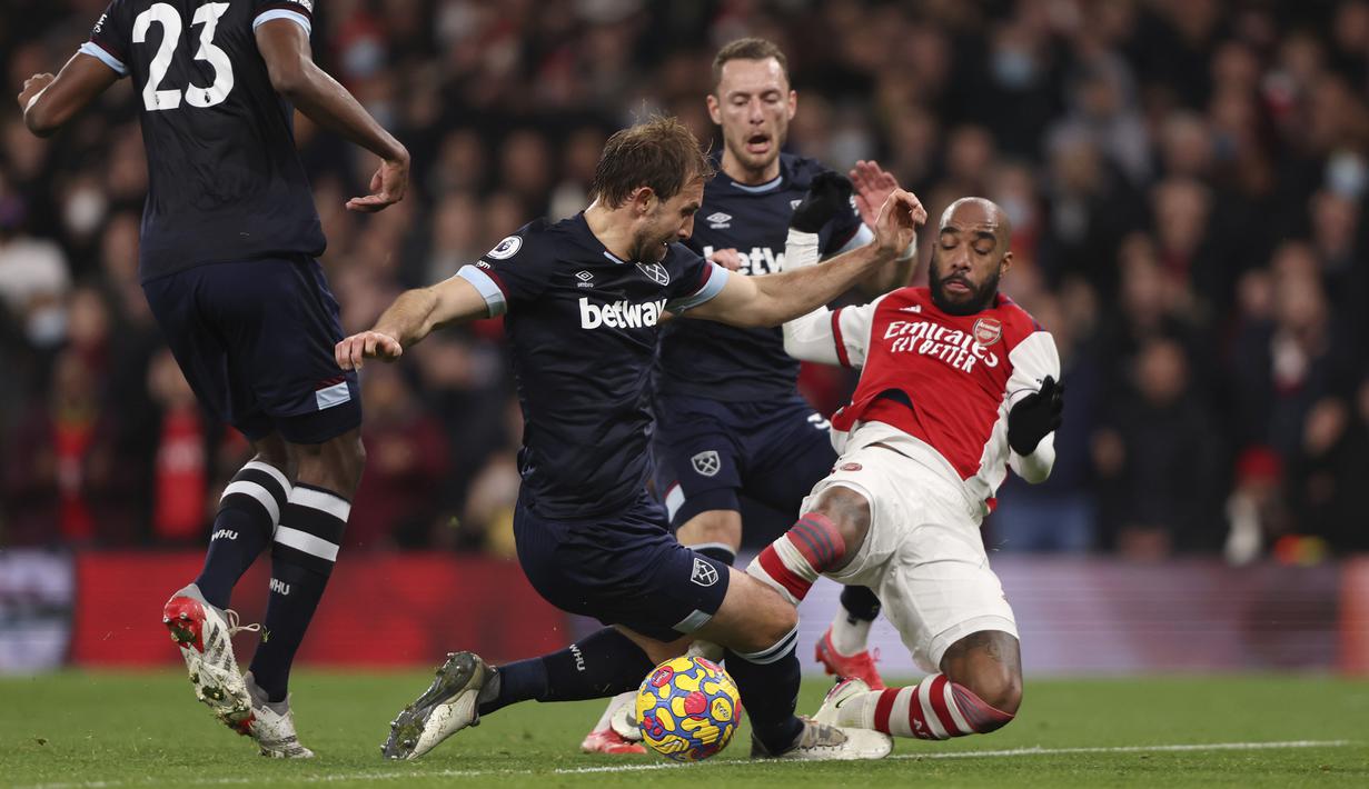 The Gunners memiliki peluang emas untuk menggandakan keunggulan pada menit ke-68 usai Alexandre Lacazette (kanan) dilanggar di kotak penalti. Sayangnya, bola eksekusinya berhasil dibaca kiper West Ham United, Lukasz Fabianski. (AFP/Ian Walton)