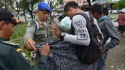Polisi Syariat Islam memberikan sarung kepada pengendara yang memakai celana pendek saat razia penertiban hukum syariat islam di Banda Aceh, Aceh, Selasa (19/9). Mereka diberi kain sarung gratis agar lututnya tidak kelihatan. (CHAIDEER MAHYUDDIN/AFP)