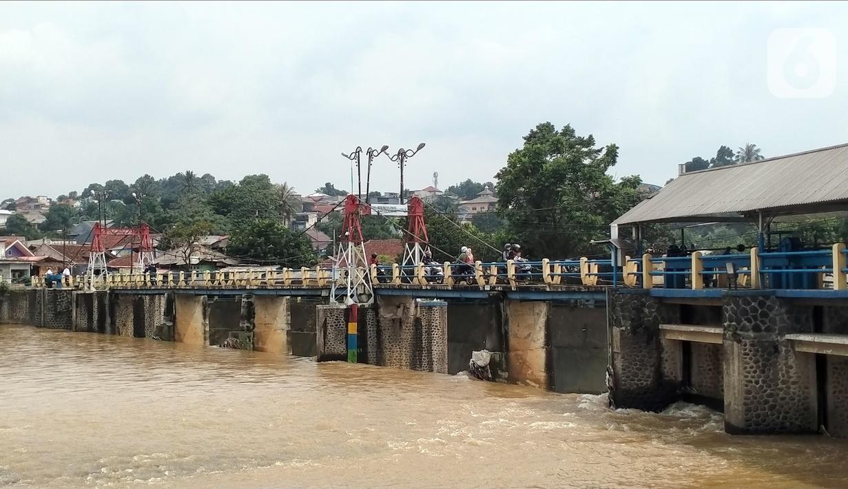 Sejumlah pengendara melintasi Bendung Katulampa, Bogor, Jawa Barat, Senin (10/10/2022). Setelah sebelumnya tinggi muka air (TMA) mencapai 220 Cm dengan status Siaga 1, pada pukul 13.23 WIB Bendung Katulampa terpantau kembali pada status normal. (Liputan.com/Magang/Aida Nuralifa)