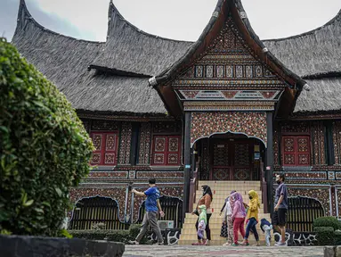 Pengunjung berjalan di depan rumah gadang di kawasan Taman Mini
Indonesia Indah, Jakarta, Minggu (12/10/2021). Pemprov DKI Jakarta memberi izin dua tempat wisata, yaitu TMII dan kawasan wisata Ancol, untuk menggelar uji coba pengoperasian pada masa PPKM level 3. (Liputan6.com/Faizal Fanani)