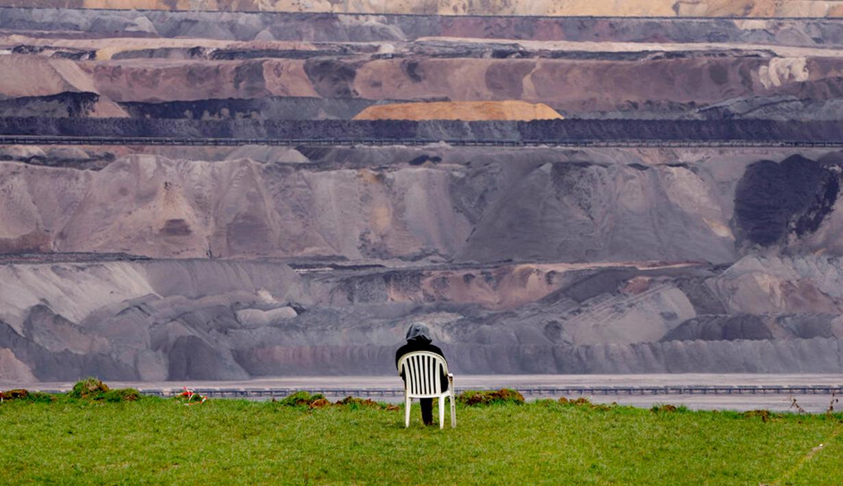 Seseorang duduk di kursi dekat tambang batu bara Garzweiler di Desa Luetzerath dekat Erkelenz, Jerman, 10 Januari 2023. Pengadilan Jerman menolak upaya terakhir para aktivis iklim untuk tinggal di desa yang ditinggalkan untuk perluasan tambang batu bara sehingga menjadi medan pertempuran antara pemerintah dan pencinta lingkungan. (AP Photo/Michael Probst)