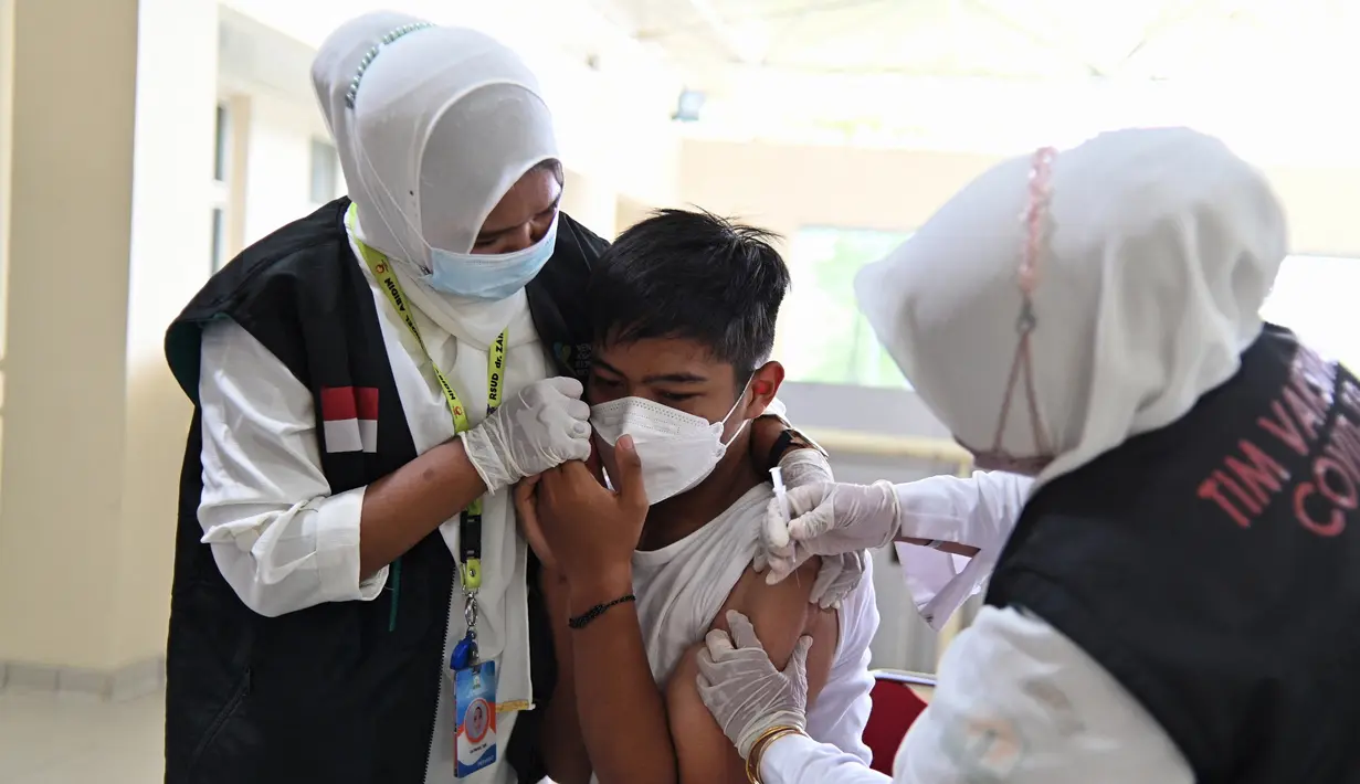 Reaksi seorang siswa SMA saat menerima dosis vaksin virus corona COVID-19 Pfizer di Rumah Sakit Zainoel Abidin, Banda Aceh, Aceh, Selasa (9/11/2021). Vaksinasi COVID-19 di kalangan warga Kota Banda Aceh tembus 80 persen. (CHAIDEER MAHYUDDIN/AFP)