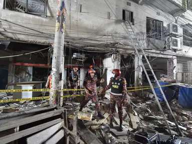 Petugas damkar memeriksa tempat kejadian setelah dugaan ledakan gas di jalanan ramai di Moghbazar, Dhaka, Bangladesh, Minggu (27/6/2021). Setidaknya tujuh orang tewas dan lebih dari 50 lainnya terluka dalam ledakan yang terjadi di lantai bawah gedung tiga lantai tersebut. (Munir Uz zaman/AFP)