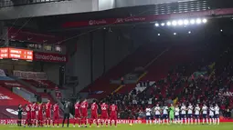 Pemain Liverpool dan Tottenham Hotspur bertepuk tangan saat memberi penghormatan kepada mantan manajer Liverpool Gerard Houllier pada pertandingan Liga Inggris di Anfield, Liverpool, Inggris, Rabu (16/12/2020). Liverpool mengudeta Tottenham dari puncak klasemen usai menang 2-1. (AP Photo/Jon Super)