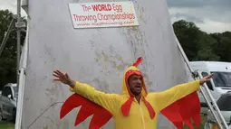 Seorang pria mengenakan kostum ayam menjadi target untuk dilempari telur saat Kejuaraan Melempar Telur 2017 di Swaton Vintage Fair di Lincolnshire, Inggris (25/6). (AFP Photo/Lindsey Parnaby)