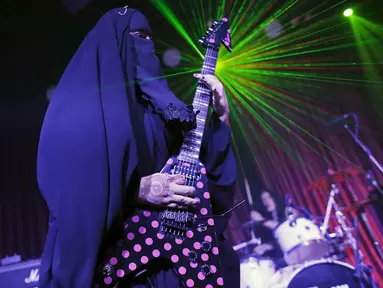 Musisi heavy metal Muslim wanita, Gisele Marie memainkan gitar listrik saat konser di Sao Paulo, Brasil (16/12/2014). Marie merupakan cucu dari kakek beragama Katolik Jerman, ia masuk Islam setelah ayahnya meninggal pada tahun 2009. (REUTERS/Nacho Doce)