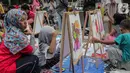 Anak-anak mewarnai gambar saat car free day (CFD) di kawasan Bundaran HI, Jakarta, Minggu (27/10/2019). Kegiatan tersebut digelar untuk melatih keterampilan motorik halus serta mengembangkan kreativitas dan imajinasi pada anak. (Liputan6.com/ Faizal Fanani)