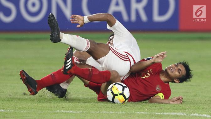 Pemain Timnas Indonesia U-19, Rachmat Irianto terjatuh saat berebut bola dengan pemain Uni Emirat Arab U-19 pada penyisihan Grup A Piala AFC U-19 2018 di Stadion GBK, Jakarta, Rabu (24/10). Indonesia unggul 1-0. (Liputan6.com/Helmi Fithriansyah)