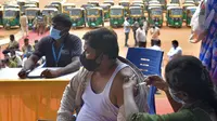 Seorang pengemudi bajaj disuntik vaksin Covid-19 CoviShield selama vaksinasi gratis untuk para pengemudi di Bangalore, India, Rabu (25/8/2021). Menurut data Kementerian Kesehatan India, hingga Senin (23/8), sebanyak 589 juta lebih dosis vaksin telah diberikan kepada warganya. (Manjunath Kiran/AFP)